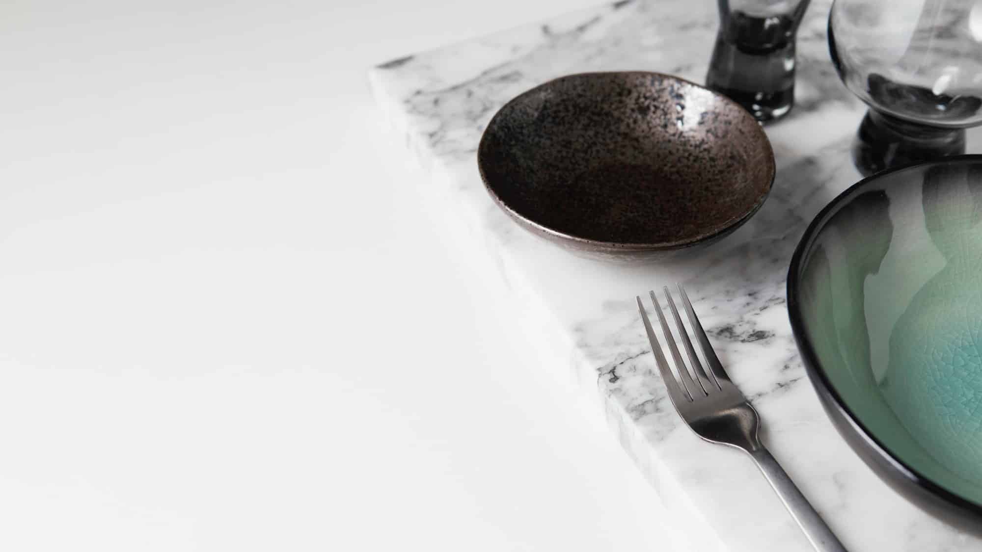 billede af marmor bord med bestik og tallerkner