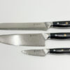 Shinto knivsæt i damaskusstål med kokkekniv, brødkniv og urtekniv på køkkenbord