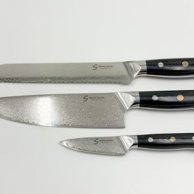 Shinto knivsæt i damaskusstål med kokkekniv, brødkniv og urtekniv på køkkenbord